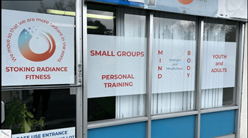 a sign in the window of a gym with small groups and personal training signs